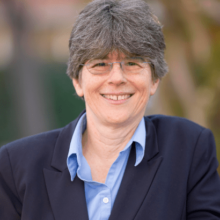 Image of Rev Kathy Fernandes director wearing blue jacket and light blue shirt